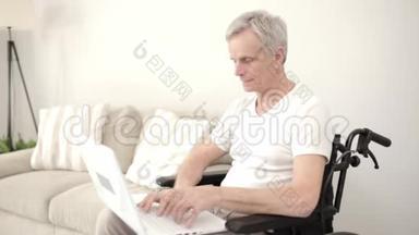 灰头土脸的男人<strong>坐在</strong>他的病房里的轮椅上，<strong>坐在</strong>笔记本<strong>电脑前</strong>。